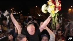 A former opposition presidential candidate Mikola Statkevich (C) meets with supporters at a bus station following his release from a prison, Minsk, Belarus, Aug. 22, 2015.