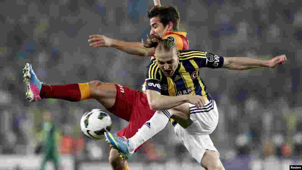 Caner Ertekin (kulia) wa klabu ya Fenerbahce akipigania mpira na Aydin Yilmaz wa Galatasaray wakati wa ligi ya juu ya Uturuki katika uwanja wa mpira wa Sukru Saracoglu Istanbul Mei 12, 2013.