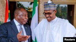 South Africa's President Cyril Ramaphosa speaks to Nigeria's President Muhammadu Buhari (R) at the State House in Abuja, Nigeria, July 11, 2018.