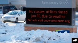 A car passes an elementary school closed due to cold weather in Des Moines, Iowa, Jan. 30, 2019.