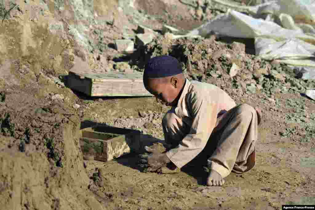 A child makes clay bricks with a mould at a brick kiln in Kandahar, Afghanistan.