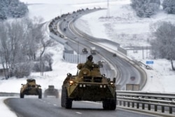 FILE - A convoy of Russian armored vehicles moves along a highway in Crimea, Jan. 18, 2022.