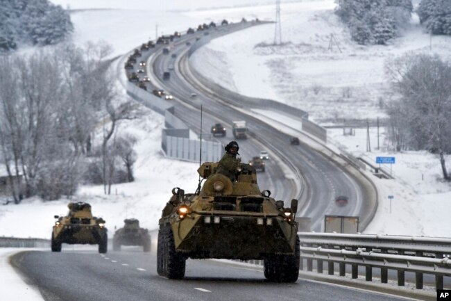 FILE - A convoy of Russian armored vehicles moves along a highway in Crimea, Jan. 18, 2022.