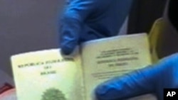 A police officer shows a passport sized during a raid early morning in Barcelona, Spain, Dec. 1, 2010. Police arrested seven people in Spain and three in Thailand in an international operation against a group suspected of forging passports for an al-Qaida