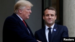 FILE - French President Emmanuel Macron shakes hands with U.S. President Donald Trump at the Elysee Palace on the eve of the commemoration ceremony for Armistice Day, 100 years after the end of the WWI, in Paris, Nov. 10, 2018.