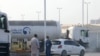 Men stand outside a storage facility of oil giant ADNOC in the capital of the United Arab Emirates, Abu Dhabi, Jan. 17, 2022. Three people were killed in a suspected drone attack that set off a blast and a fire in Abu Dhabi, officials said.