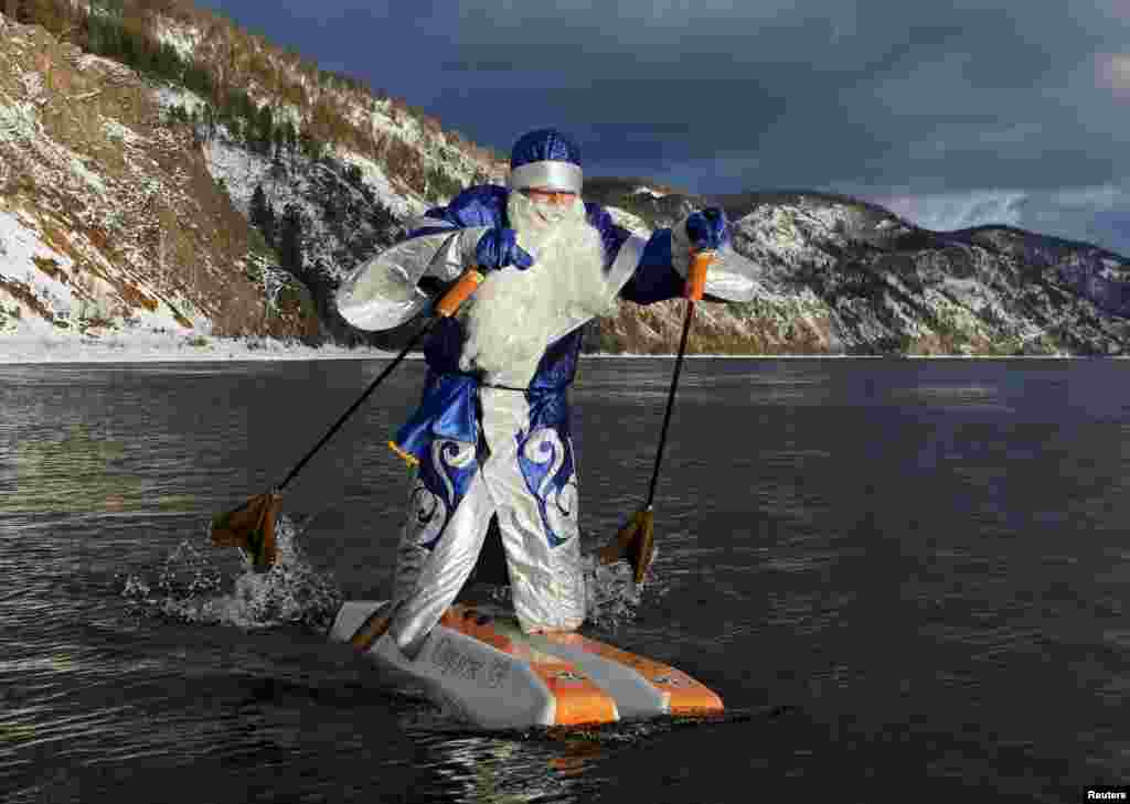 Nikolai Vasilyev, 62, dressed as Father Frost, Russian equivalent of Santa Claus, water-skis on the Yenisei River outside Siberian city of Krasnoyarsk, Russia,.