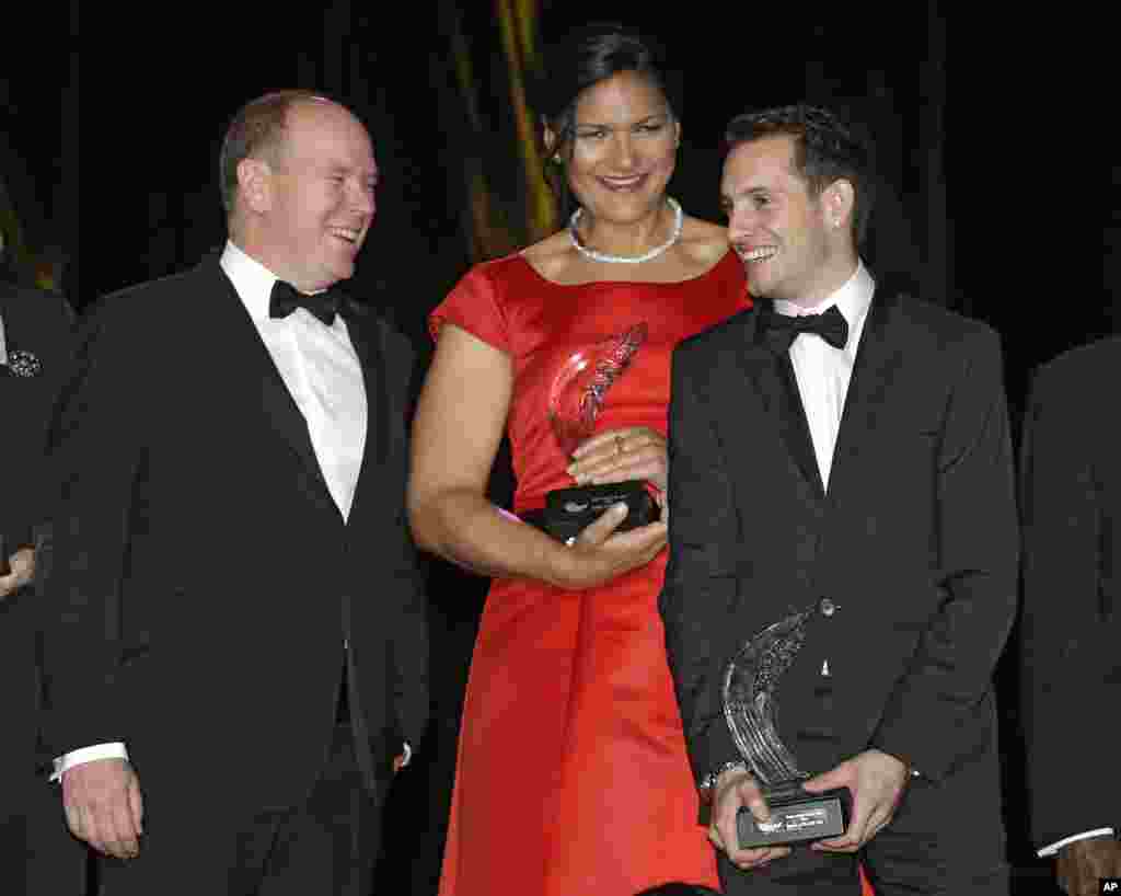 Prince Albert II de Monaco, à gauche, sourit avec la lanceuse de poids de la Nouvelle-Zélande Valerie Adams et le perchiste français Renaud Lavillenie, tenant leur &quot;prix des athlètes de l&#39;année 2014&quot;, le vendredi 21 novembre 2014, à Monaco. 