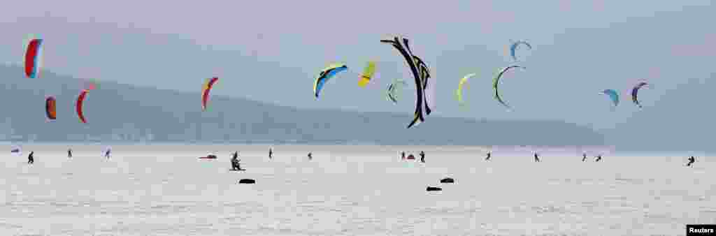 Kite boarders and kite skiers compete during an annual amateur regional snow kiting championship on the frozen Yenisei River in the Taiga district outside Russia&#39;s Siberian city of Krasnoyarsk, March 15, 2015.