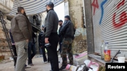 Free Syrian Army fighters stand by their weapons in the besieged area of Homs, March 9, 2013.