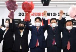 Lee Jun-Seok (tengah), ketua baru oposisi utama People Power Party (PPP) mengangkat seikat bunga saat ia terpilih dengan anggota komite eksekutif baru di markas partai di Seoul, Korea Selatan, 11 Juni 2021. (Foto: Kim Min-Hee via REUTERS)