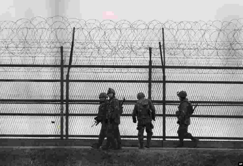 South Korean army soldiers patrol along a barbed wire fence near the demilitarized zone between the two Koreas in Paju, South Korea, March 2, 2015.