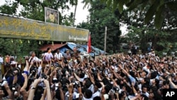 Burma's pro democracy leader Aung San Suu Kyi addresses her supporters from her house compound after her release from house arrest in Yangon, 13 Nov. 2010