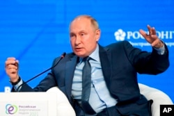 FILE - Russian President Vladimir Putin gestures while speaking at the plenary session of the Russian Energy Week in Moscow, Russia, Oct. 13, 2021.