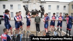 Cyclists and crew members talk with a cyclist about strategies in front of the Tedworth House recovery center in Britain. They are competing in the Race Across America for Help for Heroes. The military charity works with wounded veterans by providing treatment and career training. Left to right: Joe Townsend, Jaco van Gass, Robert James Donald Cromey-Hawke, Ryan Gray, Andrew Perrin, Mark Cavendish, Craig Preece, Stuart Croxford, Adam Clark, Micheal Swain and Josh Boggi. 