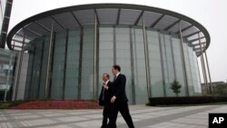 英國財政大臣喬治‧奧斯本與華為公司CEO和創始人任正非在深圳參觀華為總部會晤之前一道走過一座會議廳。（2013年10月16日資料照片）