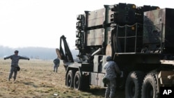 FILE - U.S. troops from 5th Battalion of the 7th Air Defense Regiment are seen next to a missile battery at a test range in Sochaczew, Poland, March 21, 2015.