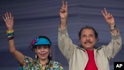 FILE - Nicaragua's President Daniel Ortega, right, and first lady Rosario Murillo, wave to supporters during an event commemorating the 36th anniversary of the Sandinista National Liberation Front withdrawal to Masaya, in Managua, Nicaragua, July 3, 2015.