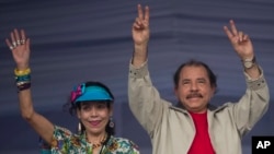 FILE - Nicaragua's President Daniel Ortega, right, and first lady Rosario Murillo, wave to supporters during an event commemorating the 36th anniversary of the Sandinista National Liberation Front withdrawal to Masaya, in Managua, Nicaragua, July 3, 2015.