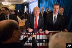 Republican presidential candidate Donald Trump signs autographs during a campaign stop at the Radisson Hotel in Nashua, New Hampshire, Jan. 29, 2016.