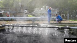 Dr Francis Hassard and Nigel Janes sample partially treated wastewater for COVID-19 as part of a study at the Cranfield University Wastewater Treatment Works in Cranfield in Cranfield, Britain in this undated photograph. (Christian Trampenau/Cranfield University via REUTERS)