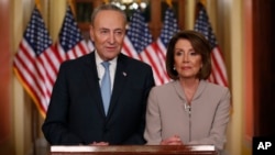 House Speaker Nancy Pelosi, right, and Senate Minority Leader Chuck Schumer pose for photographers after speaking on Capitol Hill in response President Donald Trump's prime-time address on border security, in Washington, Jan. 8, 2019.