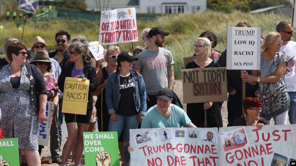 Manifestantes protestan en Escocia contra la visita del presidente de EE.UU., Donald Trump. Están en un playa cercana al Club de Golf Turnberry, propiedad del líder estadounidense. Julio 14 de 2018. Un activista en parapente que voló con un letrero cerca del campo de golf fue arrestado, informó la policía escocesa.