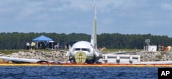 A charter plane carrying 143 people and traveling from Cuba to north Florida sits in a river at the end of a runway, May 4, 2019 in Jacksonville, Fla.