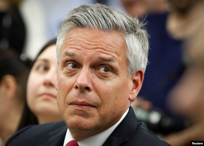 ທ່ານ ຈອນ ຮັນສ໌ແມນ (Jon Huntsman), ເອກອັກຄະລັດຖະທູດ ສະຫະລັດ ປະຈໍາຣັດເຊຍ, ຫລຽວເບິ່ງໃນຂະນະຢູ່ກອງປະຊຸມຖະແຫລງຂ່າວ ໂດຍທ່ານ ຈອນ ໂບລຕັນ (John Bolton) ຢູ່ມຢສກູ ໃນວັນທີ 27 ມິຖຸນາ, 2018
