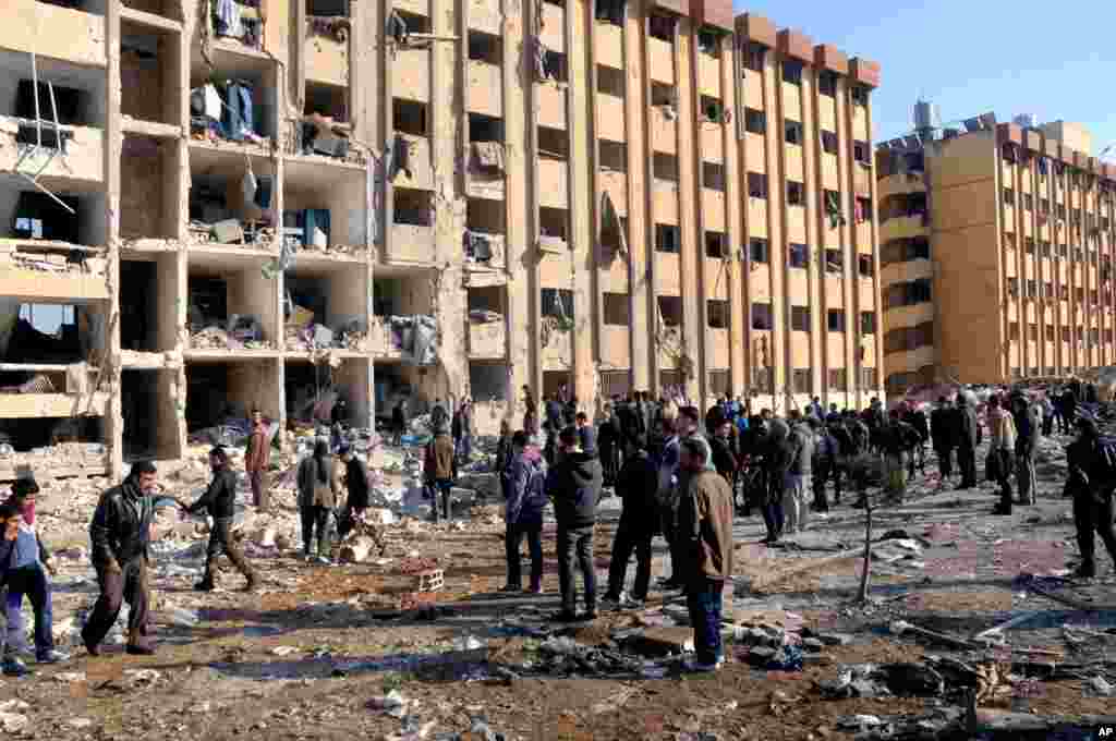 In this photo released by the Syrian official news agency SANA, Syrian people gather at the site after an explosion hit a university in Aleppo, Syria, Jan. 15, 2013.