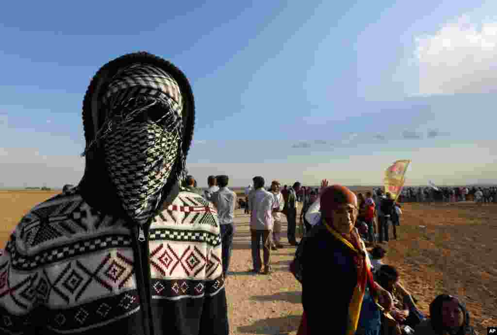 About 1000 Kurdish activists from Istanbul, who arrived in response to a call for mass mobilization by the imprisoned leader of the PKK rebel group, Abdullah Ocalan, gather at the border near Suruc, Turkey, Sept. 25, 2014.