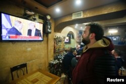 A Palestinian man watches a joint press conference by U.S. President Donald Trump and Israeli Prime Minister Benjamin Netanyahu, in a coffee shop in the West Bank city of Hebron, Feb. 15, 2017.