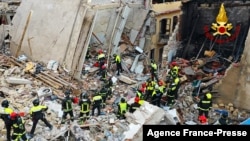 This handout picture taken and released by Italian Firefighters (Vigili del Fuoco) on December 12, 2021 shows firefighters working after a four-storey apartment building collapsed, following a gas explosion, in Ravanusa on Dec. 12, 2021.