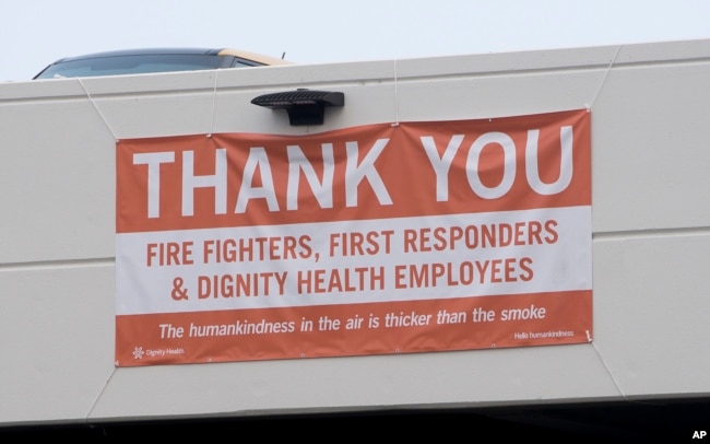 In this photo taken Aug. 2, 2018, a thank-you banner for firefighters, first responders and hospital workers hangs outside Mercy Medical Center in Redding, Calif. Dozens of staff members, including doctors, nurses and others at the medical center, are keeping the hospital running despite losing their homes to the flames.