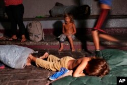 A child yawns after he is woken by Mexican immigration authorities who pushed camping migrant families from a park in Tapachula, Mexico, May 28, 2019. Authorities cleared the park and the makeshift encampment of Haitians and African migrants outside the immigration detention center near the Guatemala border.
