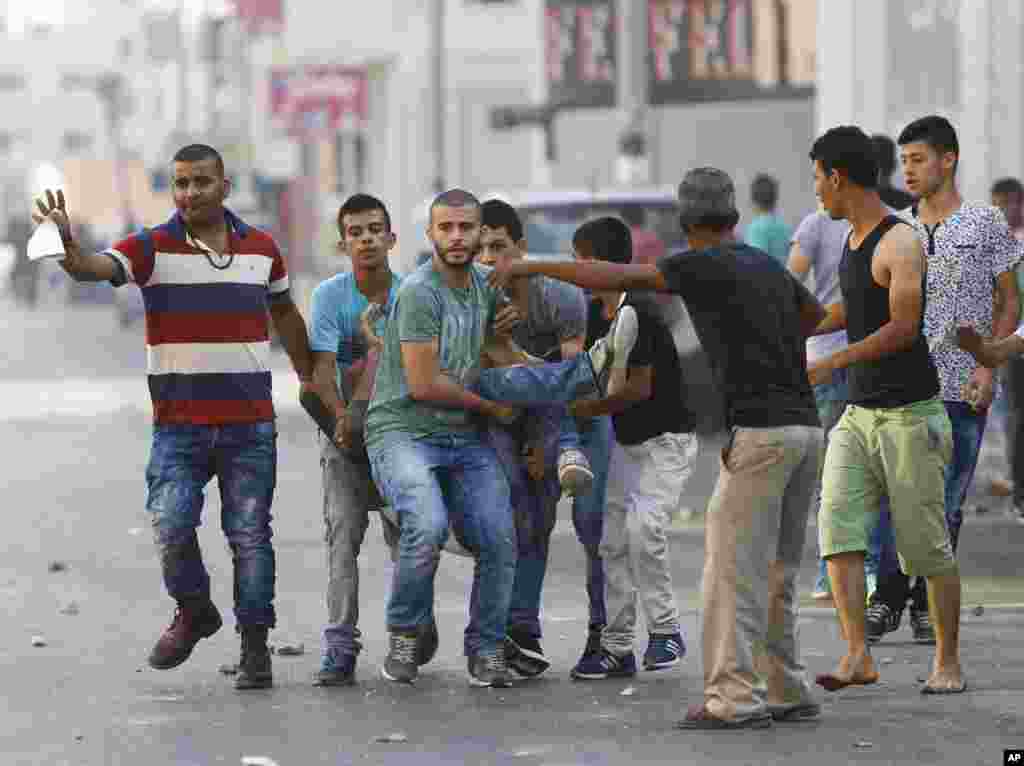 Warga Palestina menggotong seorang pria yang terluka dalam penggerebekan oleh militer Israel di Jenin, Tepi Barat (4/10). Pasukan Israel menembak dan melukai sedikitnya 18 orang Palestina dalam aksi kekerasan di kamp pengungsi Jenin, menurut seorang direktur rumah sakit Palestina. (AP/Majdi Mohammed)