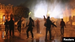 Para demonstran anti-pemerintah melemparkan batu dan bom molotov ke arah petugas keamanan yang berjaga di depan Istana Keperesidenan Mesir (1/2). 