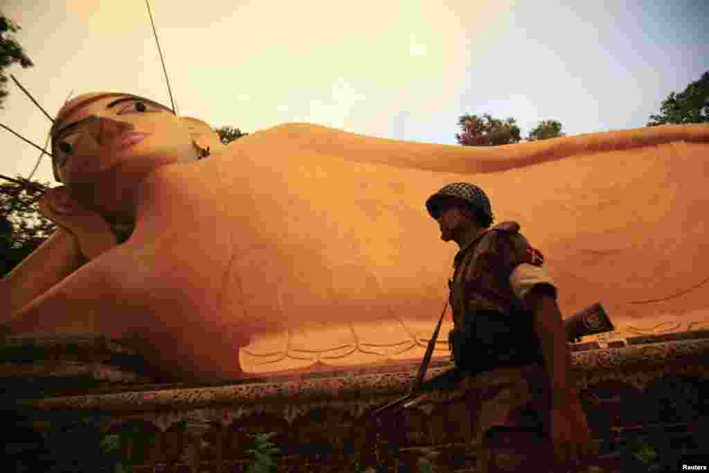 A member of the Border Guard Bangladesh (BGB) guards a Buddha sculpture after an attack by Muslims in Cox's Bazar, Bangladesh, October 1, 2012.