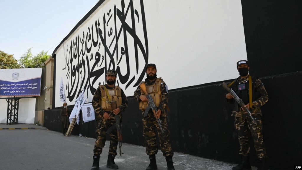 塔利班特种部队成员在喀布尔的美国驻阿富汗大使馆外一面画有塔利班旗帜的墙前站岗。（2021年9月8日）(photo:VOA)