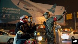 An airport security officer directs a motorcyclist at the entrance to the Benazir Bhutto International Airport in Islamabad, Pakistan, Dec. 7, 2016. 