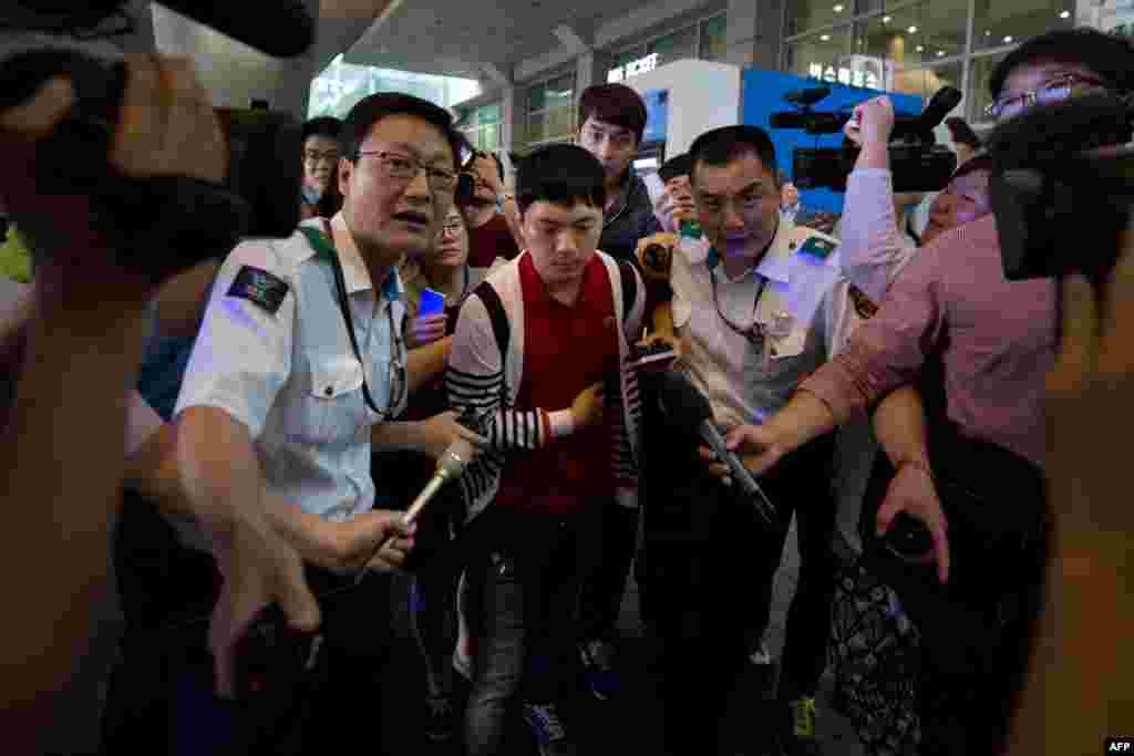 Salah seorang penyintas kecelakaan pesawat Asiana Airlines di San Francisco dikawal polisi saat tiba di bandar udara internasional Incheon di Seoul (8/7).