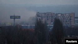 FILE - Smoke rises from a residential building during fighting between pro-Russian separatists and Ukrainian government forces near the Sergey Prokofiev International Airport in Donetsk, eastern Ukraine, Nov. 17, 2014. 