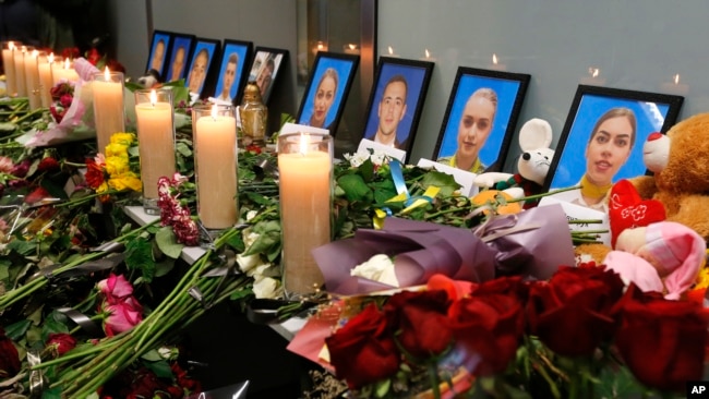乌克兰基辅国际机场中为伊朗军队在德黑兰城外击落了一架乌克兰民航客机遇难者照片前摆放的鲜花和蜡烛。（2020年1月11日）