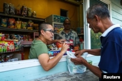 Boodsabann Chanthawong works with her husband at her stall near her house, days after she ended her novice monkhood, at the Songdhammakalyani monastery, in Bangkok, Thailand, Dec. 16, 2018.