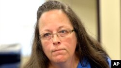 ນາງ Kim Davis ສະໝຽນສານເມືອງ Rowan ກຳລັງຟັງ ຜູ້ມາຂໍຮ້ອງ ແລະປະຕິເສດ ບໍ່ອອກໃບອະນຸຍາດແຕ່ງງານ ໃຫ້ພວກຮັກຮ່ວມເພດ.