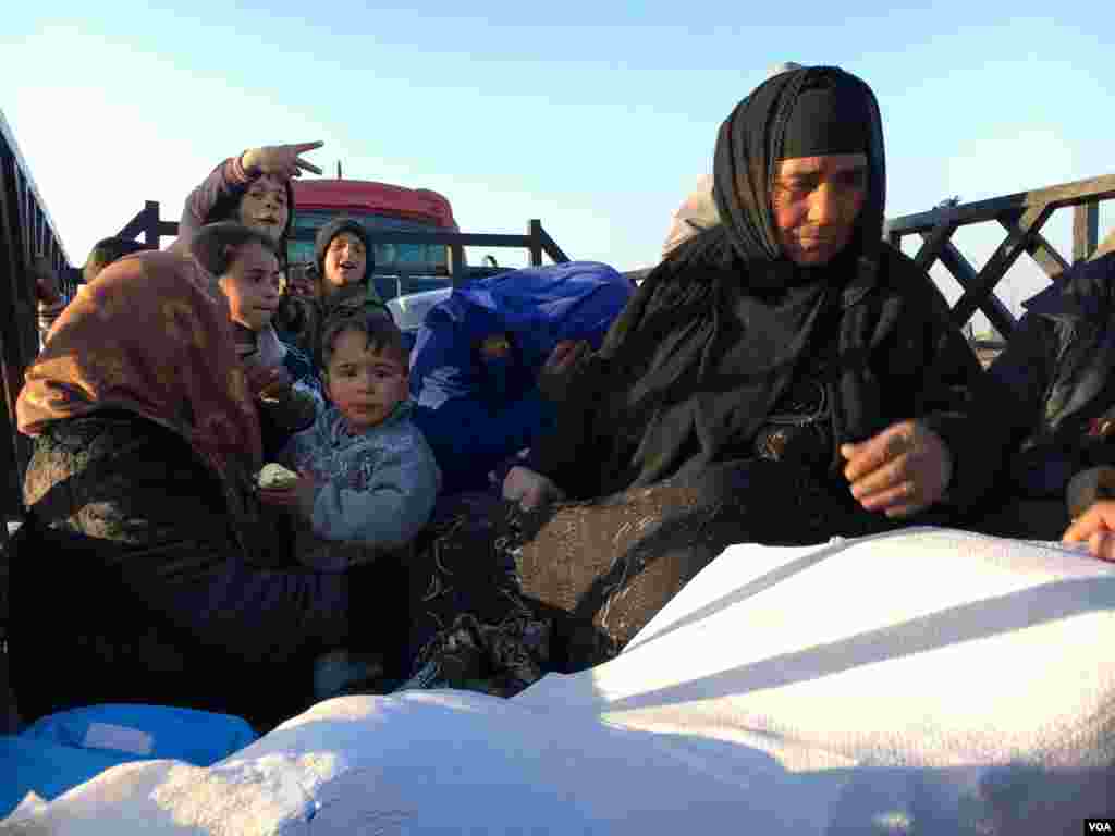 Women and children flee as U.S.-backed Iraqi forces battle Islamic State militants for control of the airport in Mosul, Iraq, Feb. 23, 2017. (K. Omar/VOA)