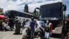 FILE - Passengers board buses traveling to Zimbabwe, amid the spread of the SARS-CoV-2 Omicron variant in Johannesburg, South Africa, Dec. 14, 2021. 