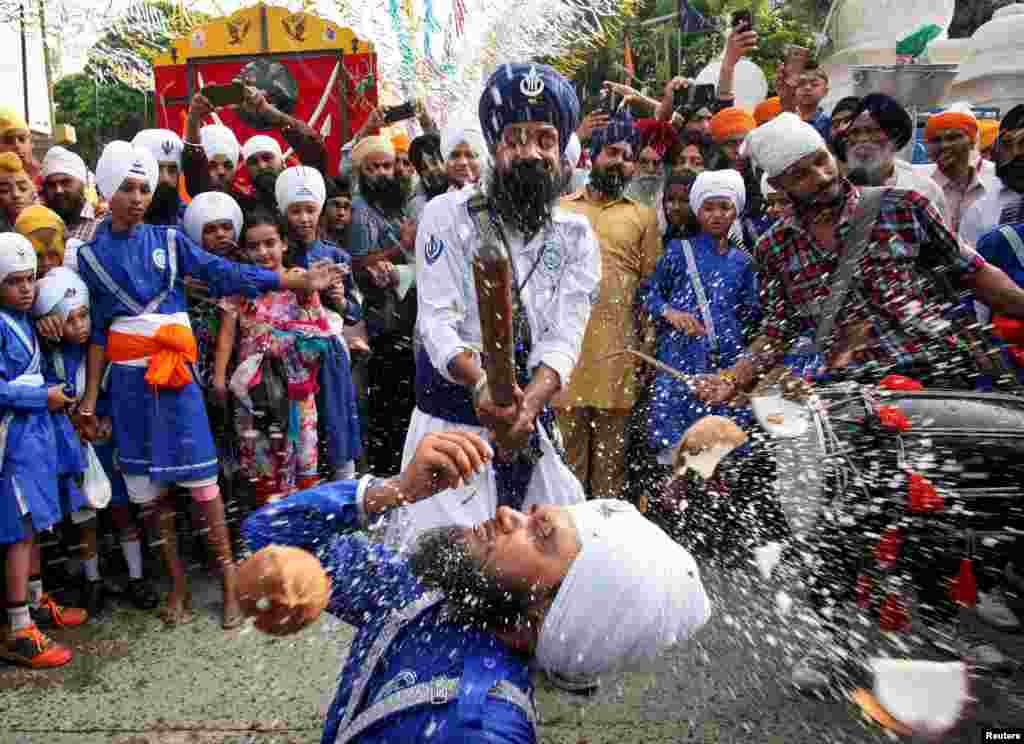 Sikh devotees perform Gatka, a traditional martial arts form during celebrations to mark the 414th anniversary of the installation of the Guru Granth Sahib, the religious book of Sikhs, in Amritsar, India.
