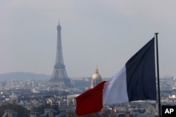 Bendera Prancis di atas cakrawala ibu kota Prancis, terlihat juga Menara Eiffel di Paris, Prancis, Jumat, 1 April 2016. Paris merupakan salah satu tujuan berlibur. (Foto: AP)