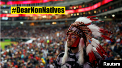 A non-Native American fan of the Cleveland Indians baseball team wears a feathered "Indian" headdress at a 2016 World Series game in Cleveland, Ohio, Oct. 30, 2016. 